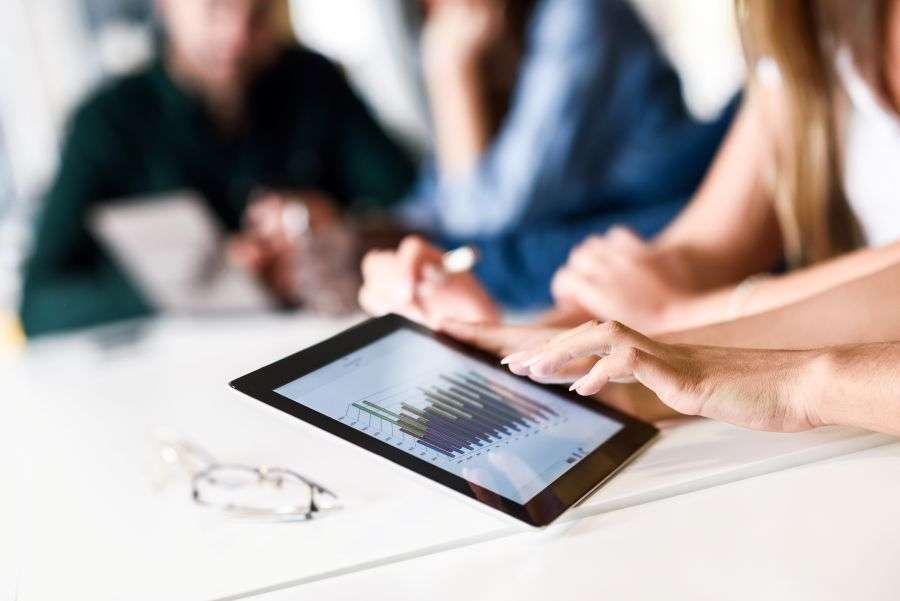Team analyzing sales data on a tablet dashboard for lead generation and business growth