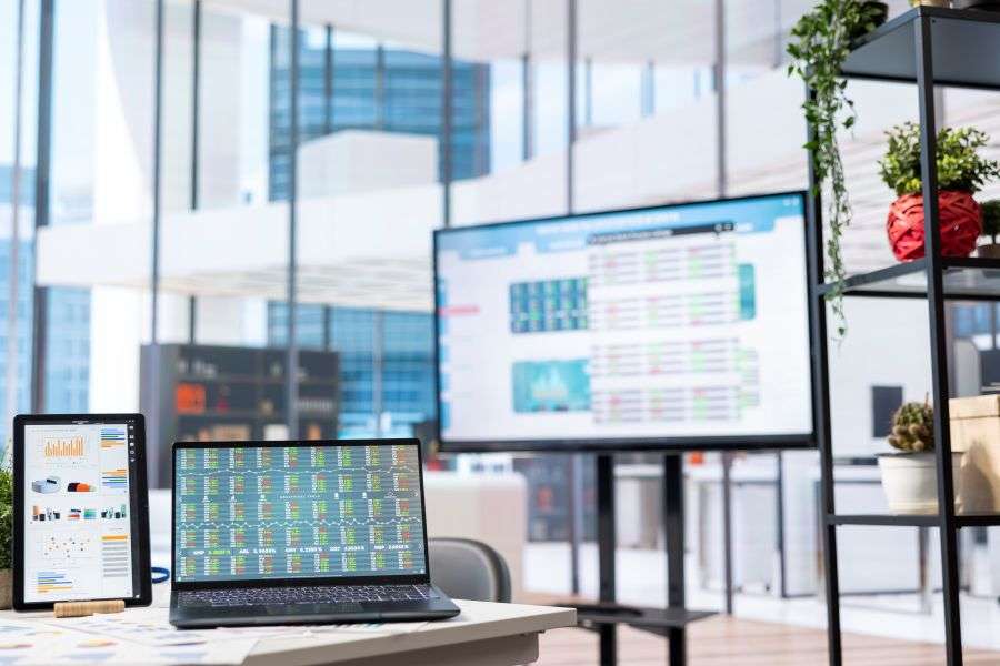 Laptop and digital dashboards in a modern office, illustrating SaaS architecture, development planning, cost estimation, and launch timeline.