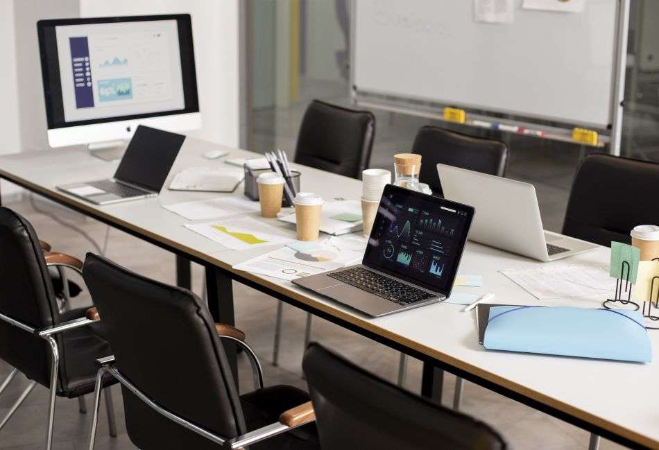 MVP development planning workspace with laptops, notes and product planning materials